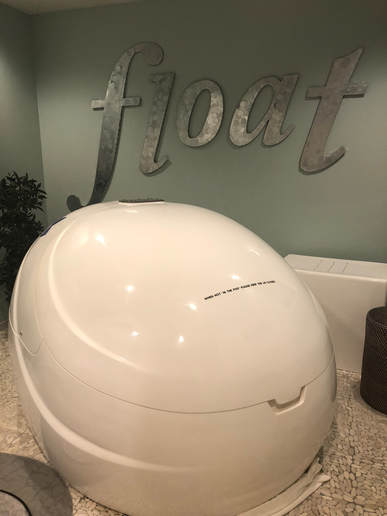 float pod with the world float in silver letters behind it on the wall